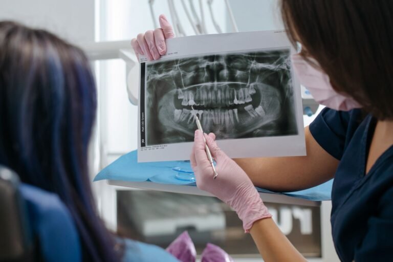 Dentist explaining gum health to a patient using a model