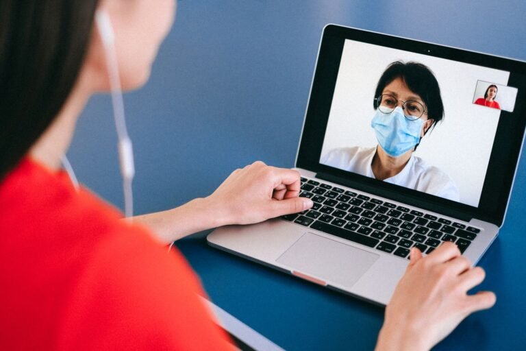 Physical therapist conducting a virtual telehealth session on a laptop